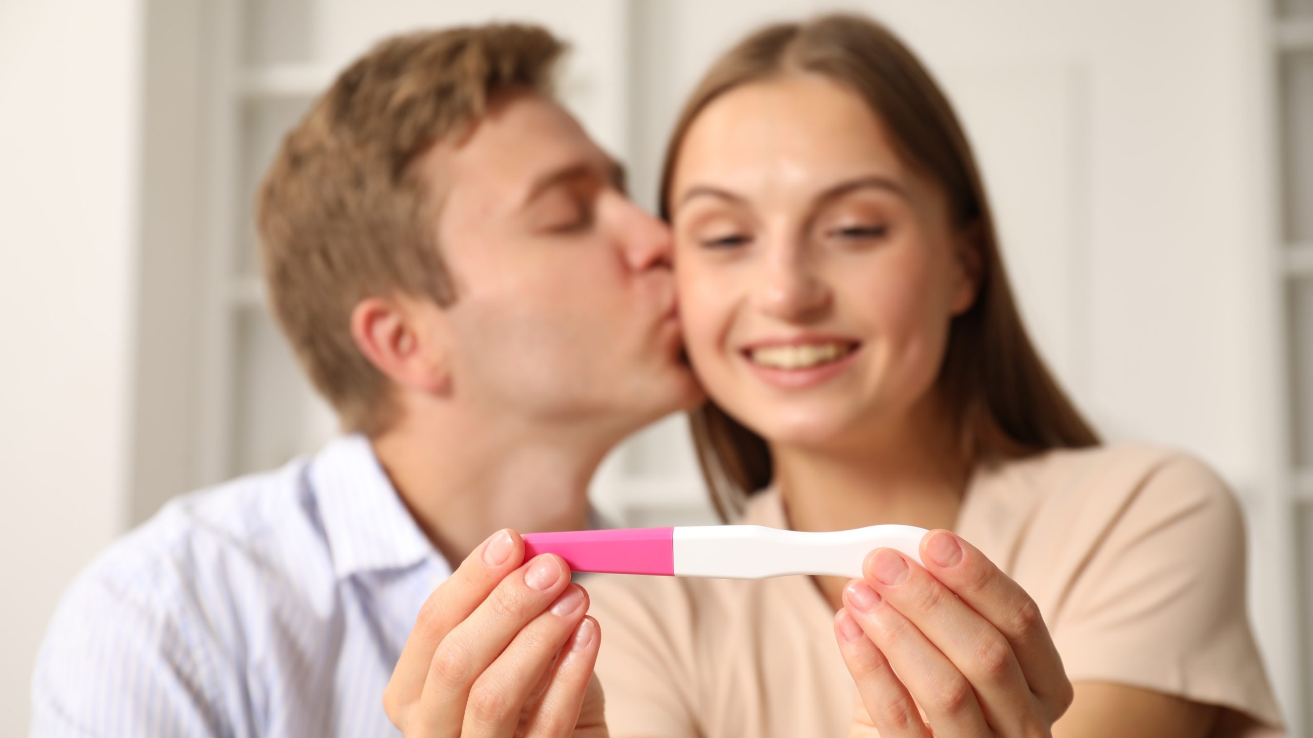 Schwangerschaft und Stillzeit - glueckliches Paar mit Schwangerschaftstest