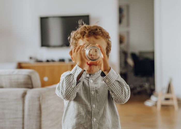 Junge trinkt ein Glas Wasser - ausreichend Flüssigkeit für ein starkes Immunsystem