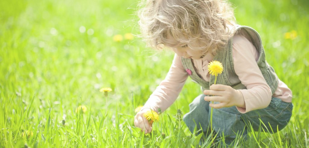 Kinder und Allergien: Mädchen sitzt im Blumenfeld