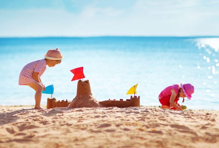 Kleine Abenteurer im Reisefieber - Kinder spielen am Sandstrand