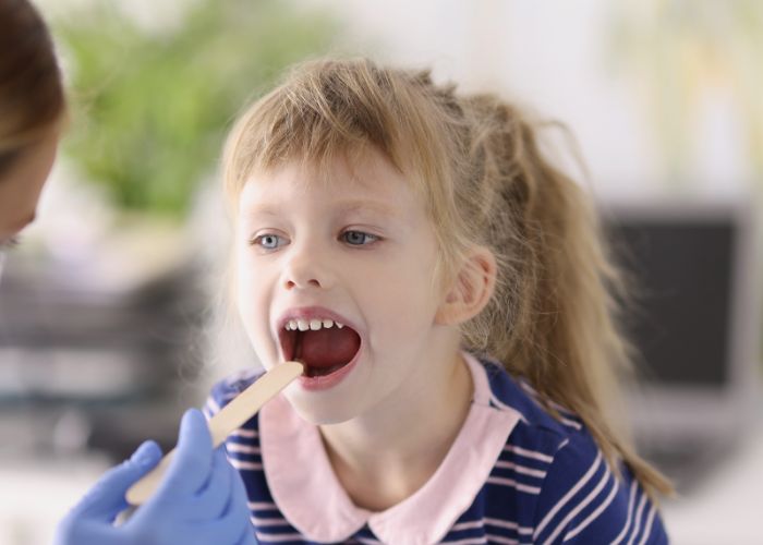 Mädchen lässt Ärztin in den Mund schauen - das Mundmikrobiom bei Kindern