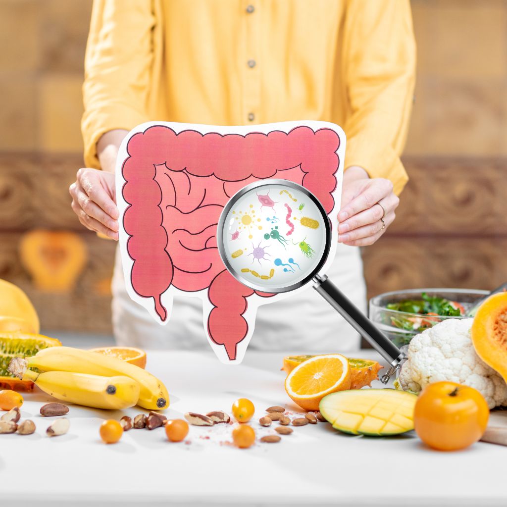 Wirkung von Präbiotika - Frau hält Darm hoch, wo Darmbakterien erkennbar sind