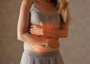 Gastritis - wenn der Magen brennt. Frau hält sich schmerzhaften Bauch.