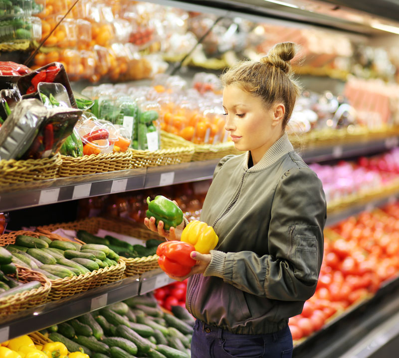 Donna con peperoni al supermercato
